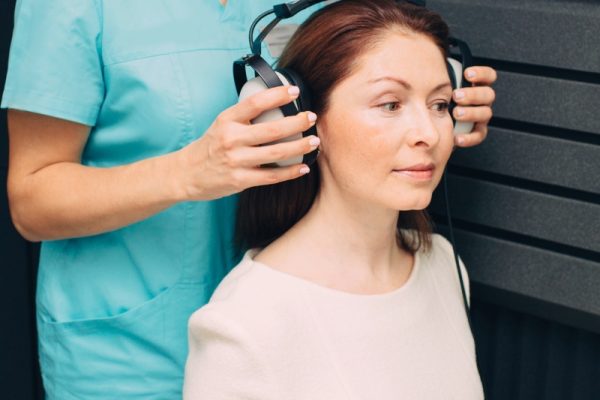 mulher se preparando fazer exame de audiometria tonal